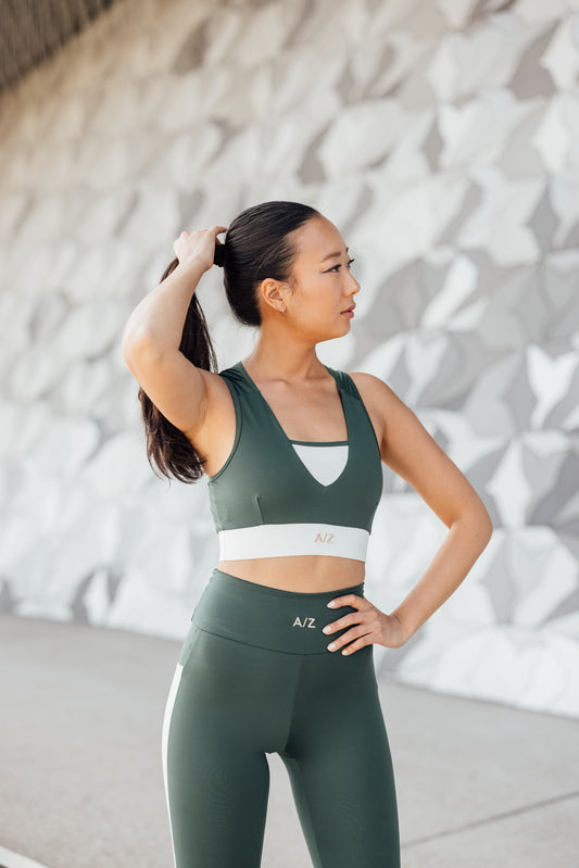 femme debout avec une main dans les cheveux, portant l'ensemble de sport bicolore azar gang, de la collection azar gang