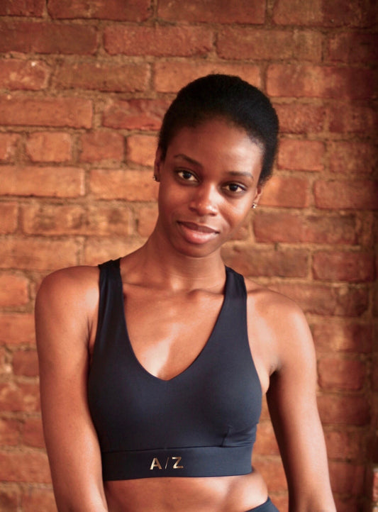 femme debout portant une brassière noire de la marque AZ/AR
