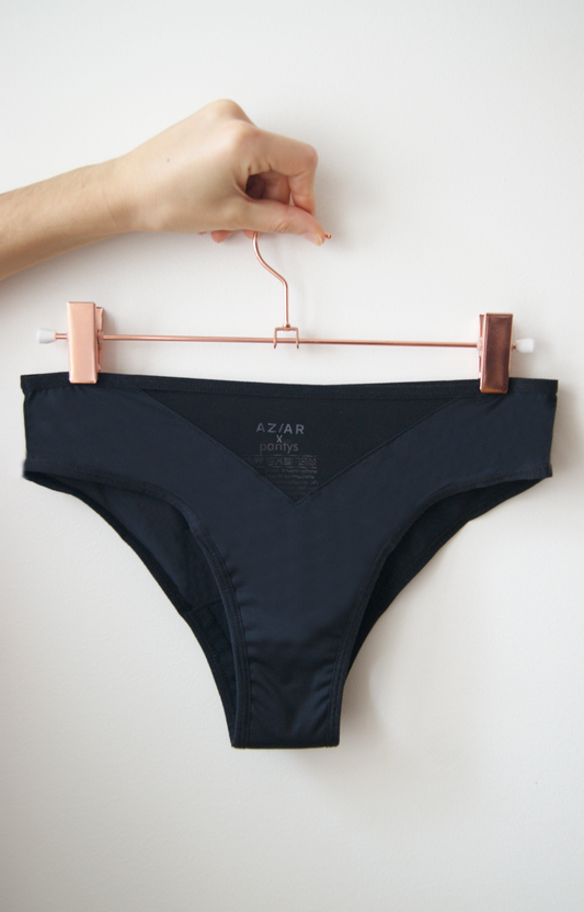 main portant un ceintre qui porte une culotte noire