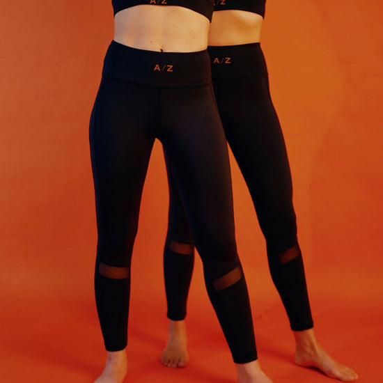 deux femmes l'une derrière l'autre qui portent l'ensemble de sport, brassière et legging noir de la marque AZAR GANG