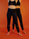 deux femmes l'une derrière l'autre qui portent l'ensemble de sport, brassière et legging noir de la marque AZAR GANG